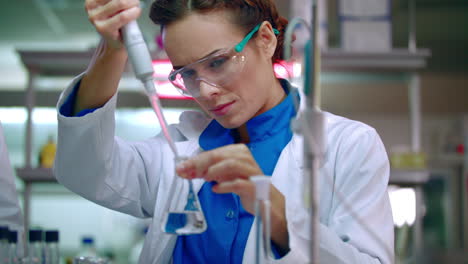Scientist-woman-working-with-chemical-reagents.-Chemical-reaction-in-lab-flask